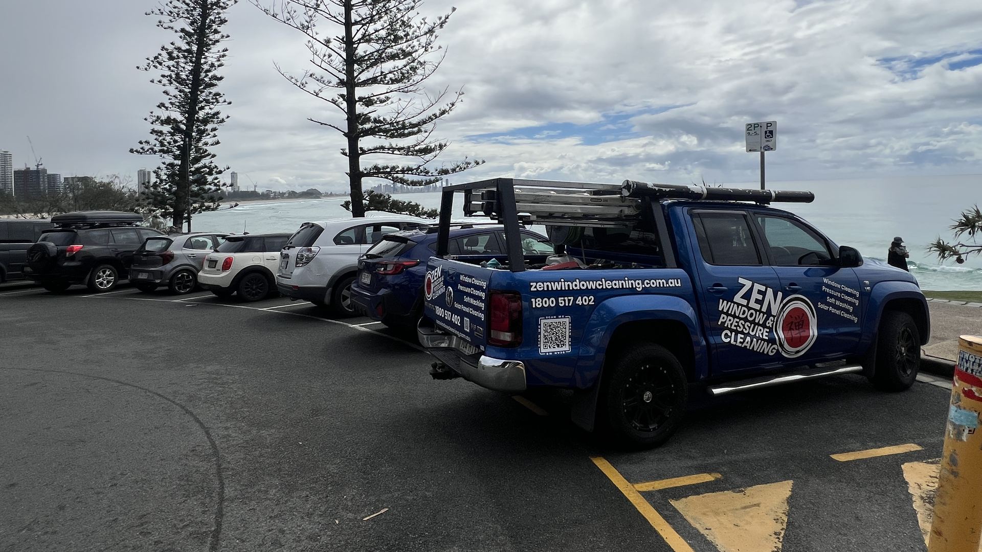 Zen Window Cleaning ute parked on Burleigh Hill with the Norfolk pines, the beach and the city skyline in the distance