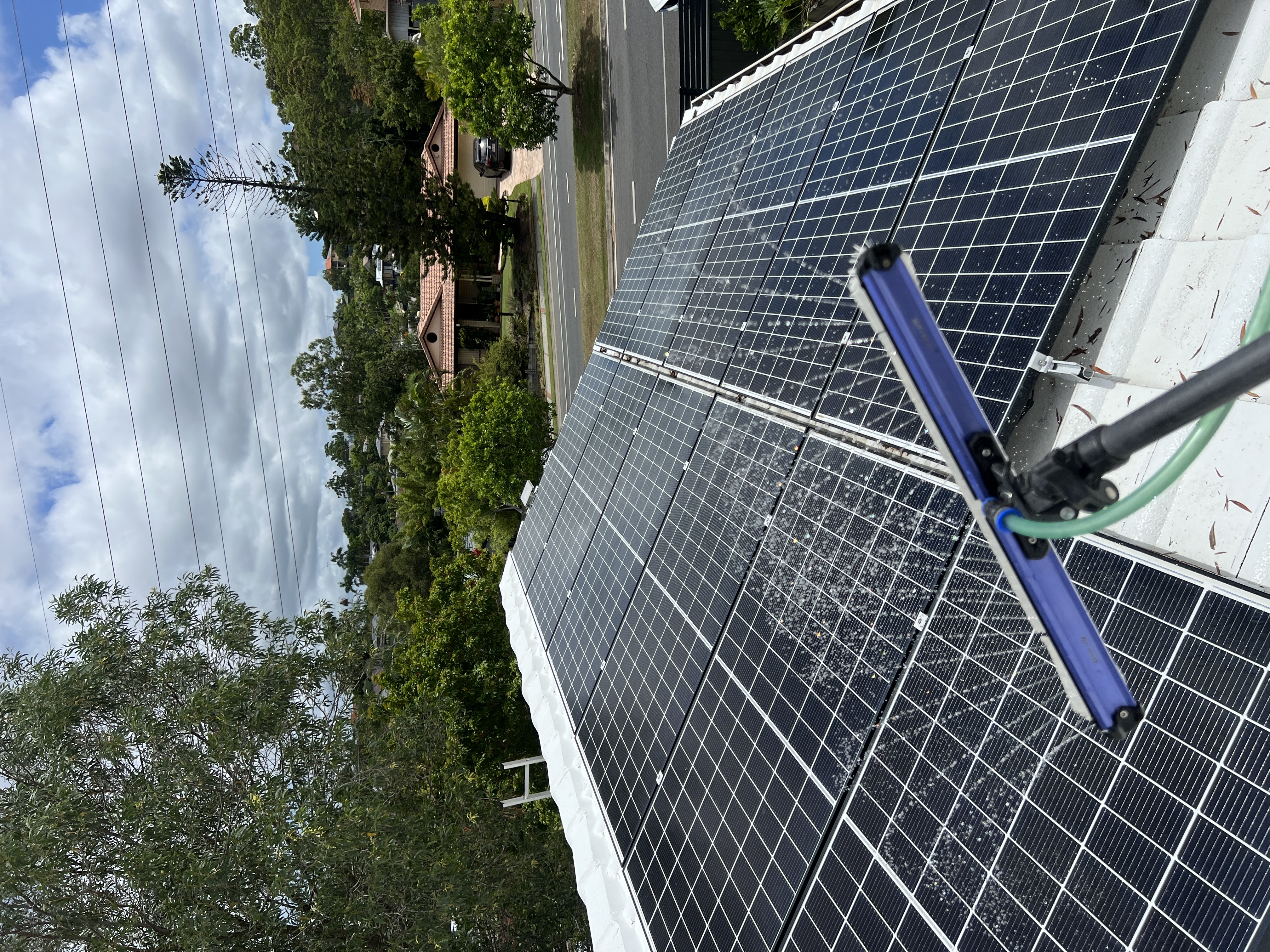 Solar panel cleaning service on a Gold Coast residential roof