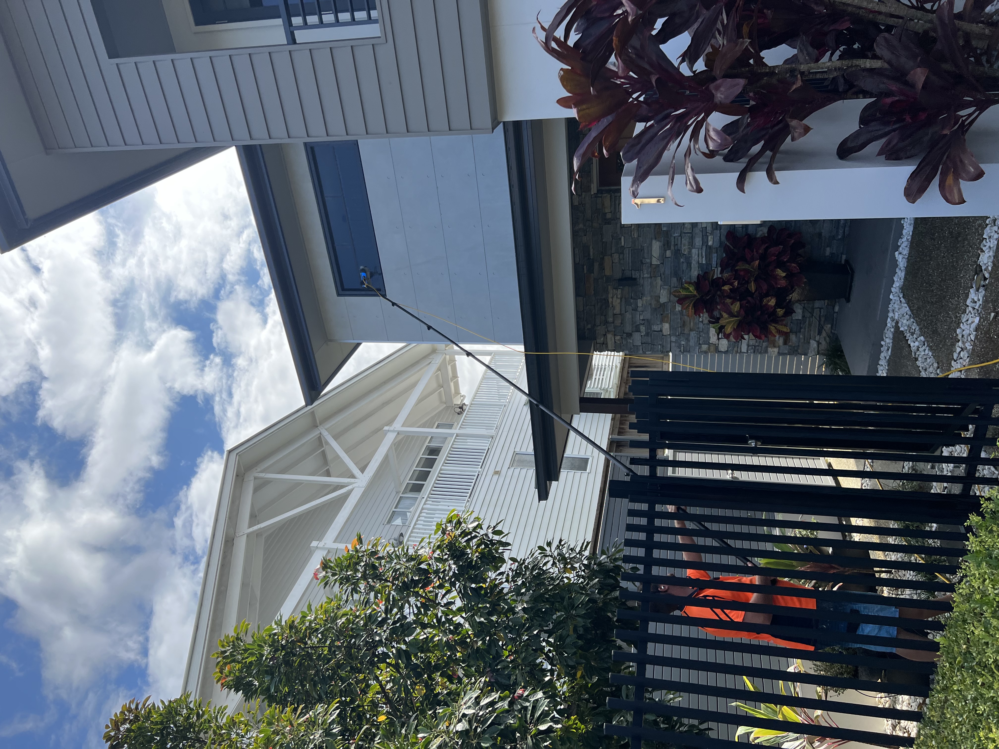 High window cleaning on Gold Coast home using water-fed pole system reaching upper storey windows
